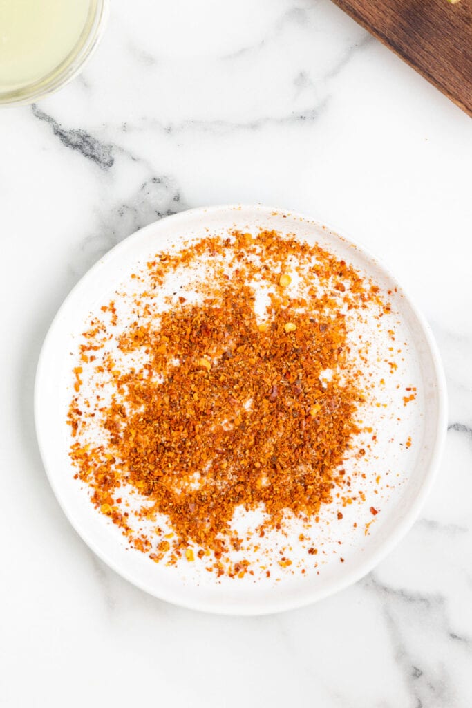 Tajín seasoning spread on a plate for rimming a margarita glass