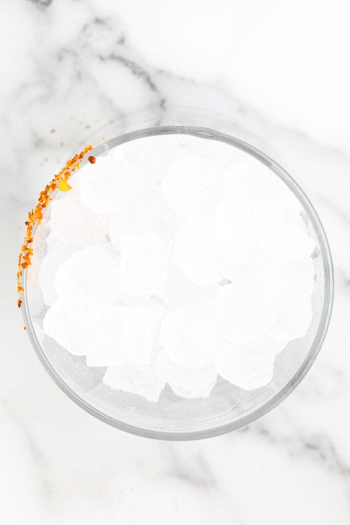 Ice-filled glass with a Tajín rim ready for a homemade margarita
