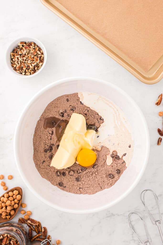 Butter, egg, and heavy cream added to the chocolate cookie mixture for Easy Turtle Cookies.