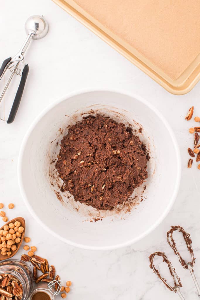 Chocolate cookie dough mixed with chopped pecans for Easy Turtle Cookies.