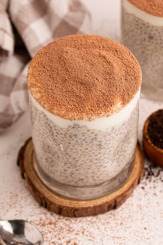 Tiramisu Chia Pudding topped with Greek yogurt and cocoa powder in a glass