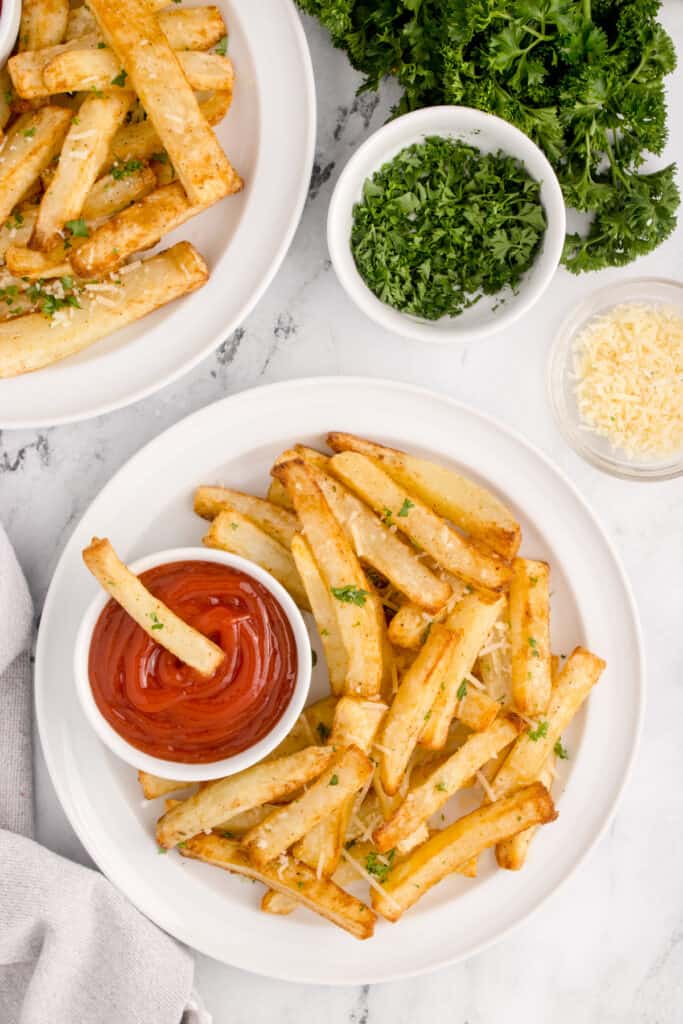 Air Fryer French Fries topped with Parmesan and parsley and served with ketchup