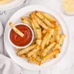 Air Fryer French Fries with Parmesan and parsley served with ketchup for dipping.