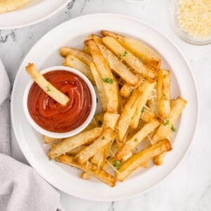 Air Fryer French Fries with Parmesan and parsley served with ketchup for dipping.