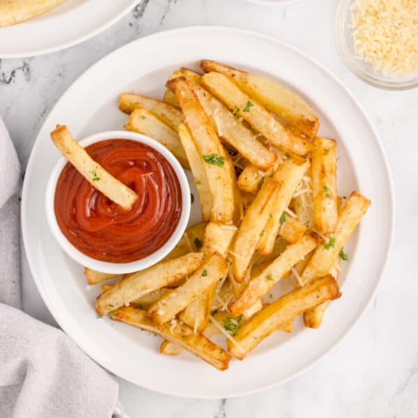Air Fryer French Fries with Parmesan and parsley served with ketchup for dipping.
