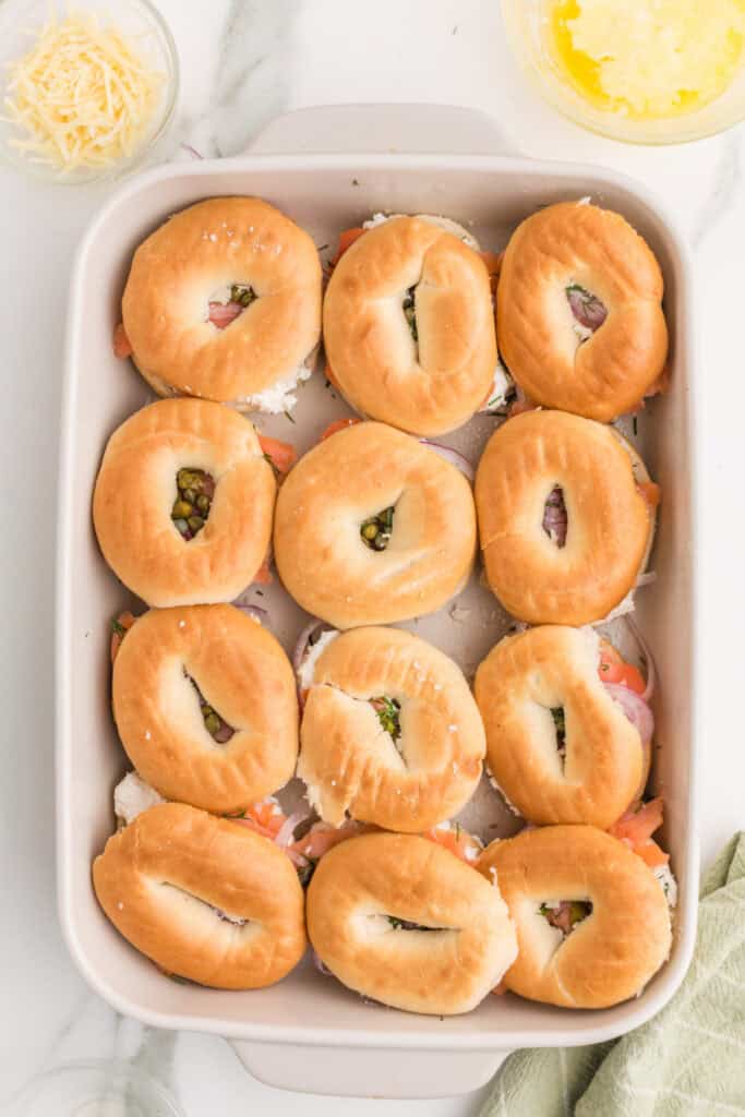 Mini bagel tops placed over smoked salmon, cream cheese, red onion, capers, and dill