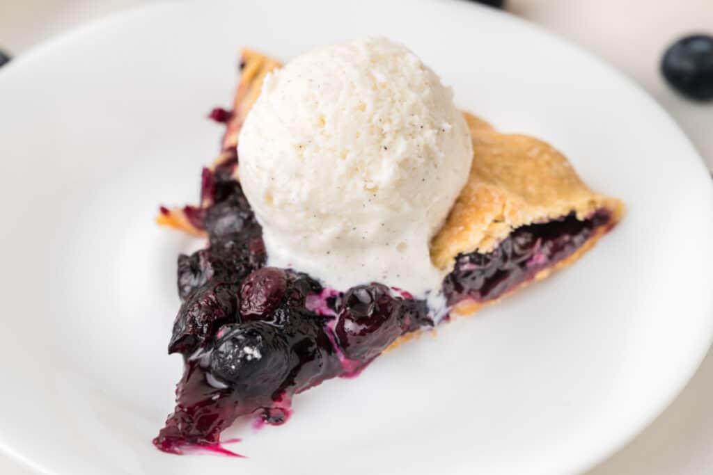 Blueberry Galette slice topped with vanilla ice cream showing thick blueberry filling and flaky crust