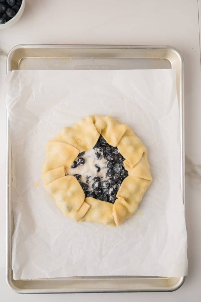 Unbaked Blueberry Galette with pie crust folded around the fresh blueberry filling