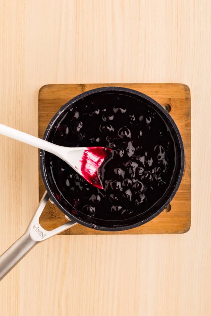 Homemade blueberry filling cooking in a saucepan until thick and jammy
