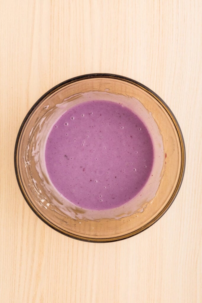 Homemade blueberry glaze mixed in a glass bowl