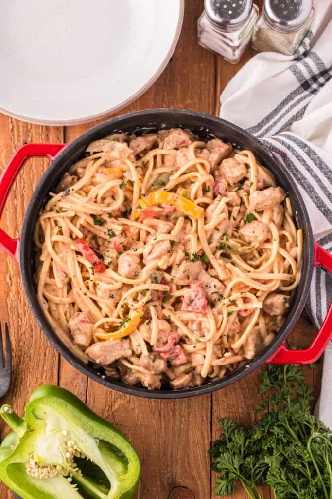 Creamy Cajun Chicken Pasta with seasoned chicken, linguine, bell peppers, tomatoes, and parsley