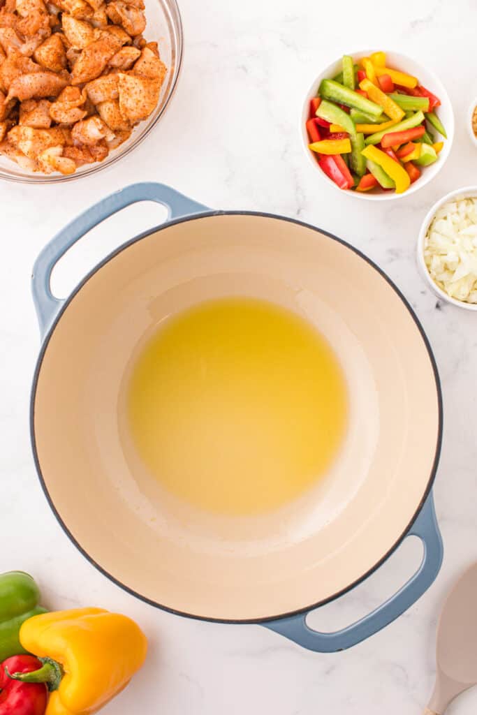 Cooking oil heating in a large Dutch oven for one-pot Cajun chicken pasta