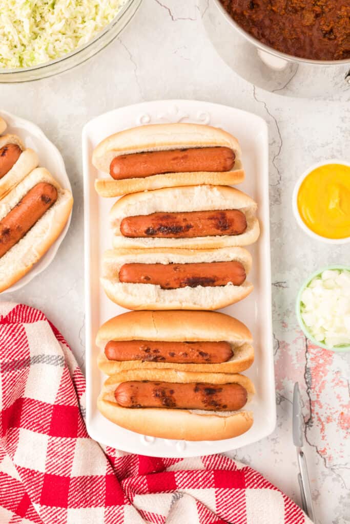Grilled hot dogs nestled in buns and ready for toppings.