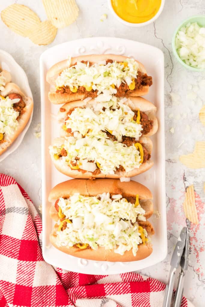 Platter of Carolina Dogs with homemade chili, creamy slaw, chopped onions, and potato chips.