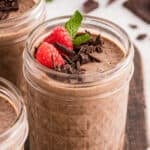 Chocolate Chia Pudding topped with fresh raspberries, chopped dark chocolate, and mint in a glass jar