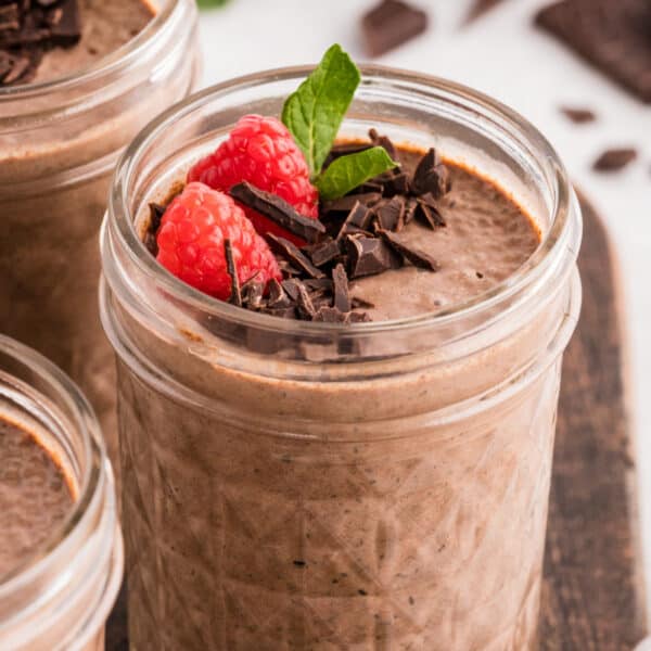 Chocolate Chia Pudding topped with fresh raspberries, chopped dark chocolate, and mint in a glass jar