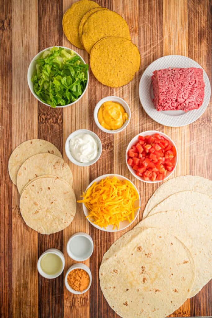 Ingredients for homemade Crunchwrap Supreme arranged on a wooden surface