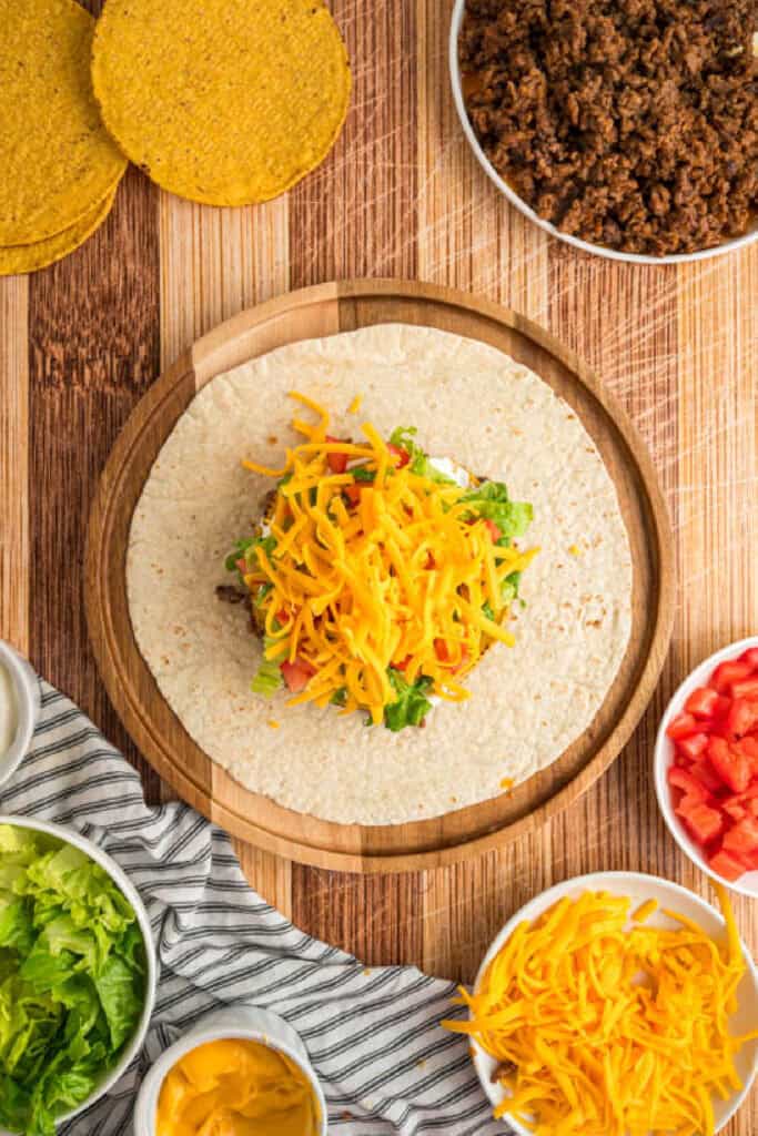 Shredded cheddar cheese added to the layered Crunchwrap filling