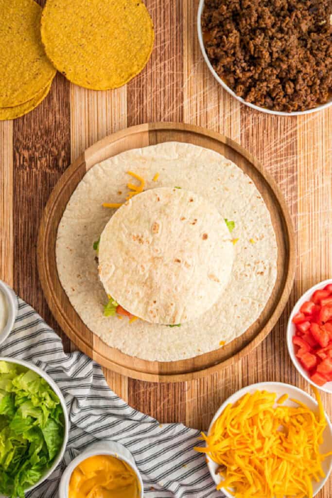 Small flour tortilla placed over the filling before folding a Crunchwrap