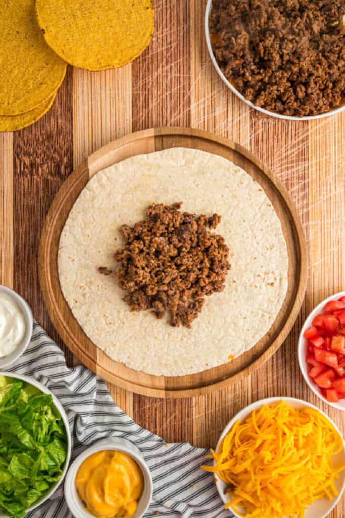 Seasoned ground beef placed in the center of a large flour tortilla