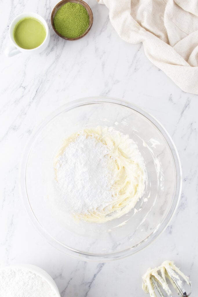 Powdered sugar added to whipped butter for vanilla buttercream frosting