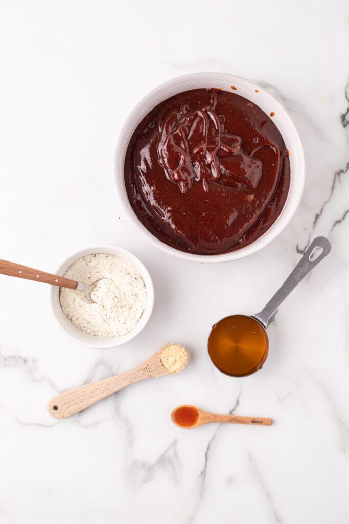 Ingredients for homemade BBQ ranch sauce arranged on a white marble surface