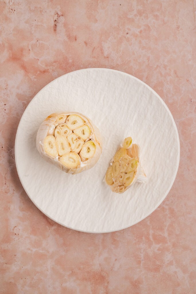 Whole garlic bulb with the top sliced off to expose the individual cloves