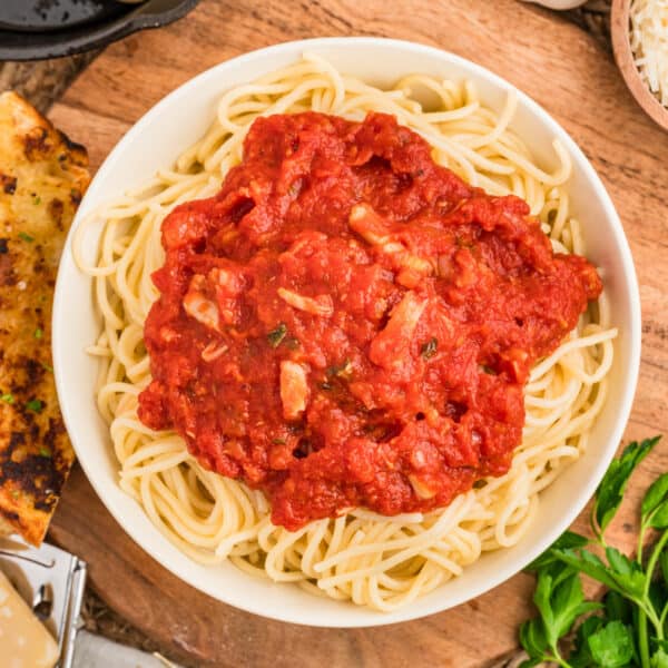 Roasted garlic pasta sauce served over spaghetti with garlic bread, Parmesan, and fresh herbs.