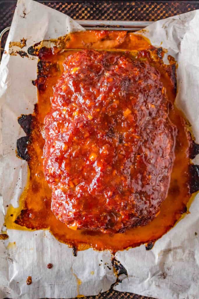 Smoked meatloaf coated with glossy peach bourbon BBQ sauce after glazing