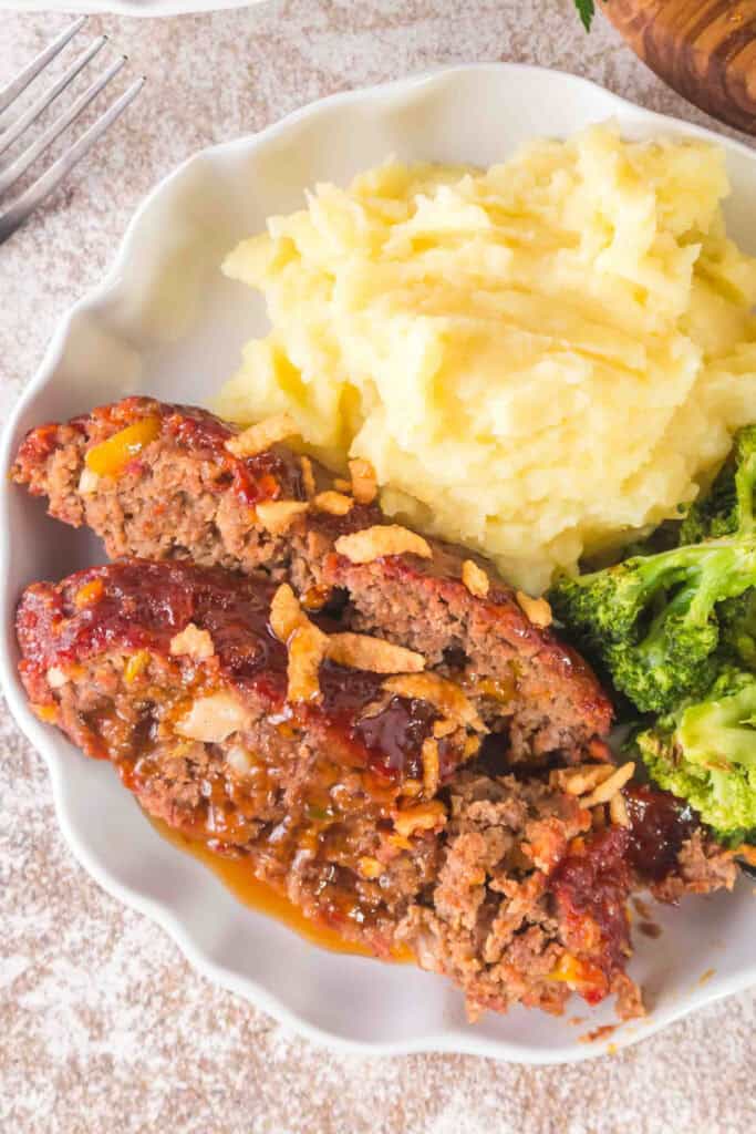 Smoked Cowboy Meatloaf slices with crispy fried onions, mashed potatoes, and broccoli