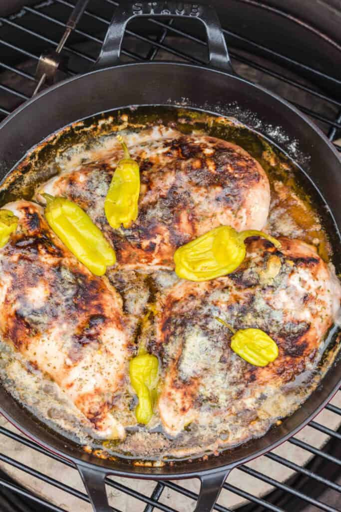 Cooked Mississippi chicken breasts with pepperoncini and buttery pan juices on the smoker