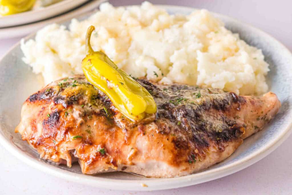 Smoked Mississippi Chicken with pepperoncini served alongside creamy mashed potatoes