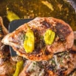Close-up of smoked Mississippi chicken breast topped with pepperoncini over the skillet