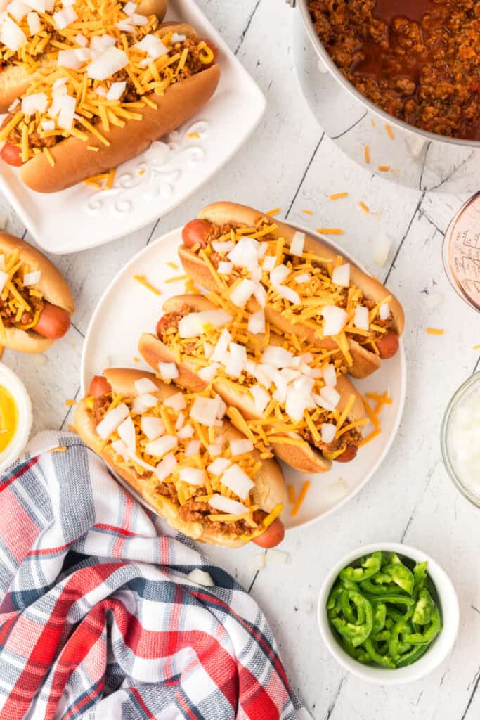 Texas Chili Dogs topped with chili, shredded cheddar cheese, and chopped onions