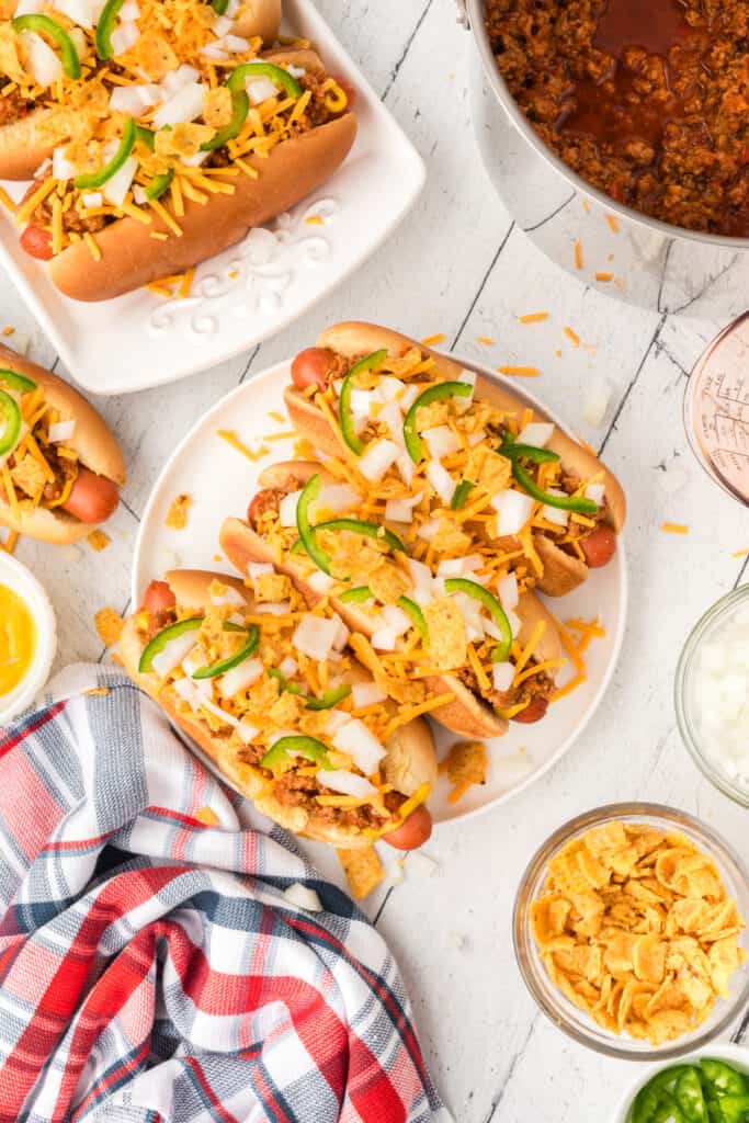 Loaded Texas Chili Dogs topped with chili, cheddar cheese, onions, jalapeños, and crushed corn chips