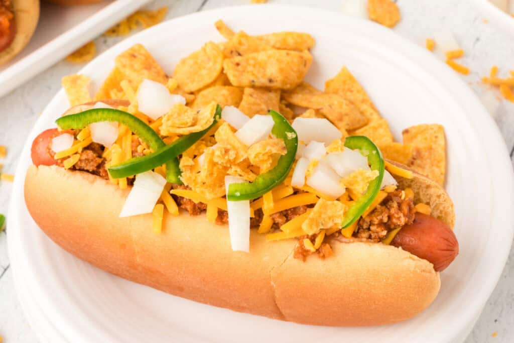 Texas Chili Dog served with corn chips and topped with beef chili, cheddar cheese, onions, and jalapeños