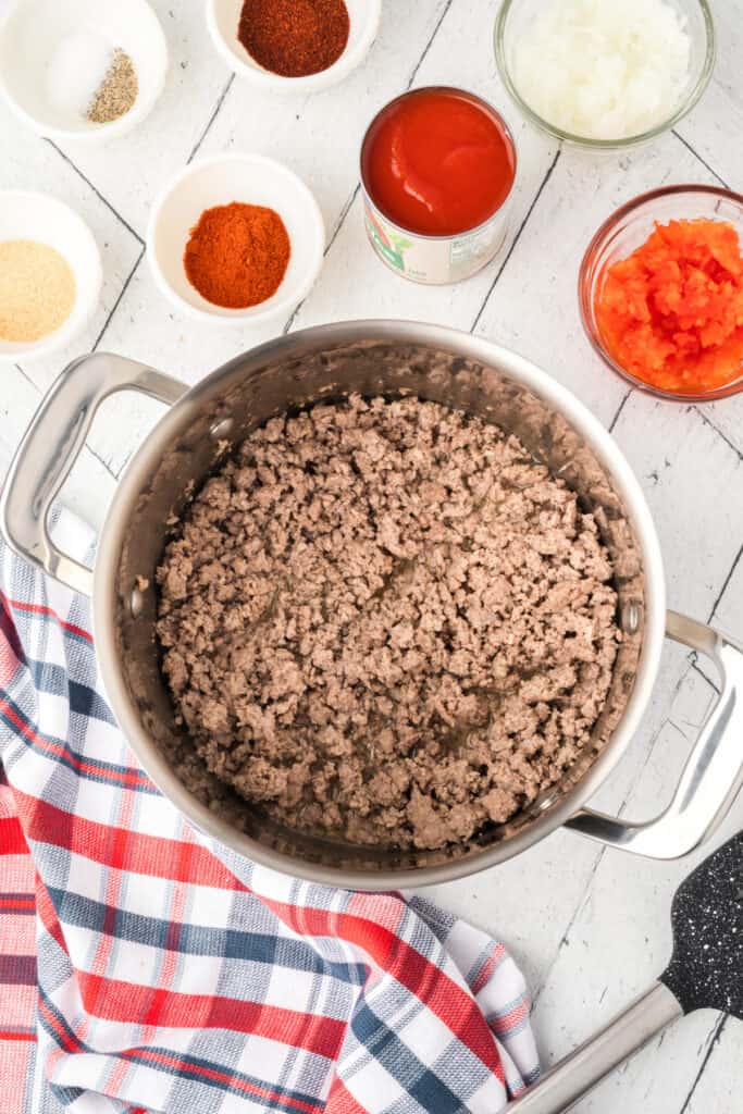 Ground beef browned and crumbled in a large pot for Texas Chili Dogs