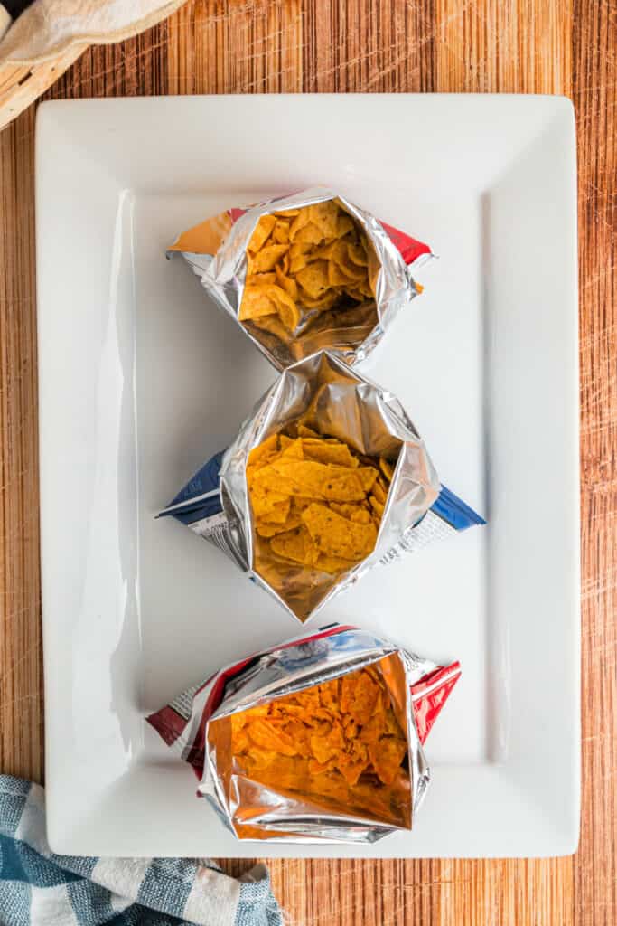Three opened bags of corn chips arranged for assembling Walking Tacos