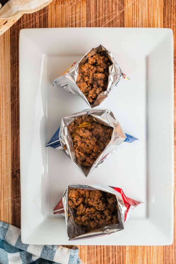 Seasoned ground beef spooned into individual bags of corn chips