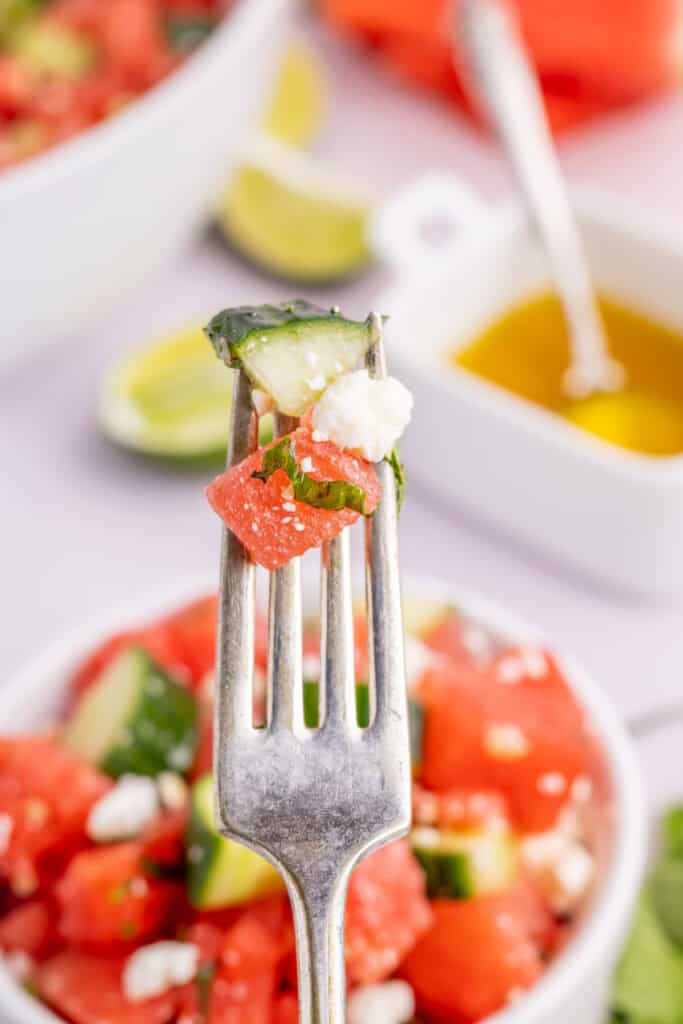 Close-up forkful of Watermelon Feta Mint Salad with watermelon, cucumber, feta, and fresh mint.