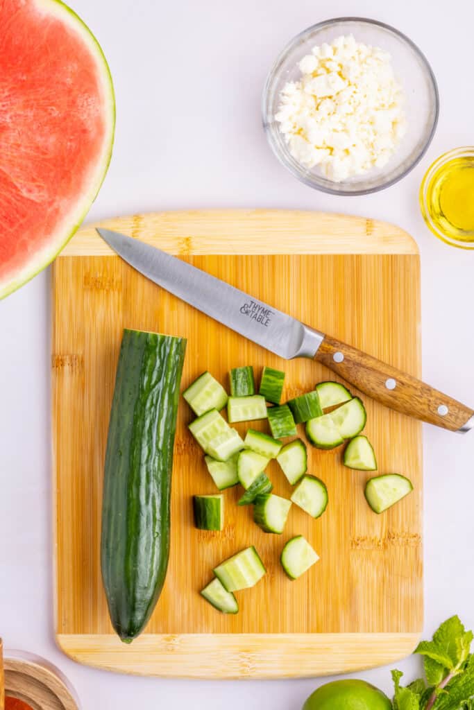 Chopping fresh English cucumber into bite-sized pieces for Watermelon Feta Mint Salad.