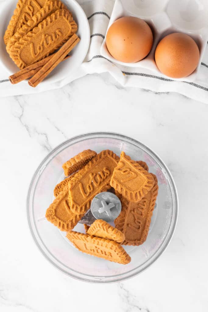 Biscoff cookies in a food processor ready to be crushed for the mini pumpkin cheesecake crust.