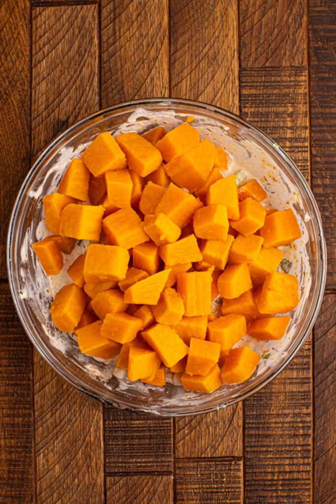 Cooked sweet potato cubes added to the creamy seasoned dressing mixture before being gently folded together