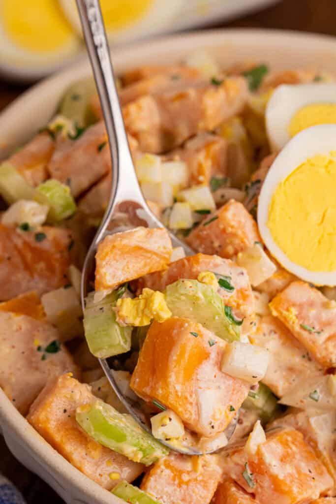 Spoonful of creamy Sweet Potato Salad with sweet potato, celery, onion, chopped egg, and fresh parsley