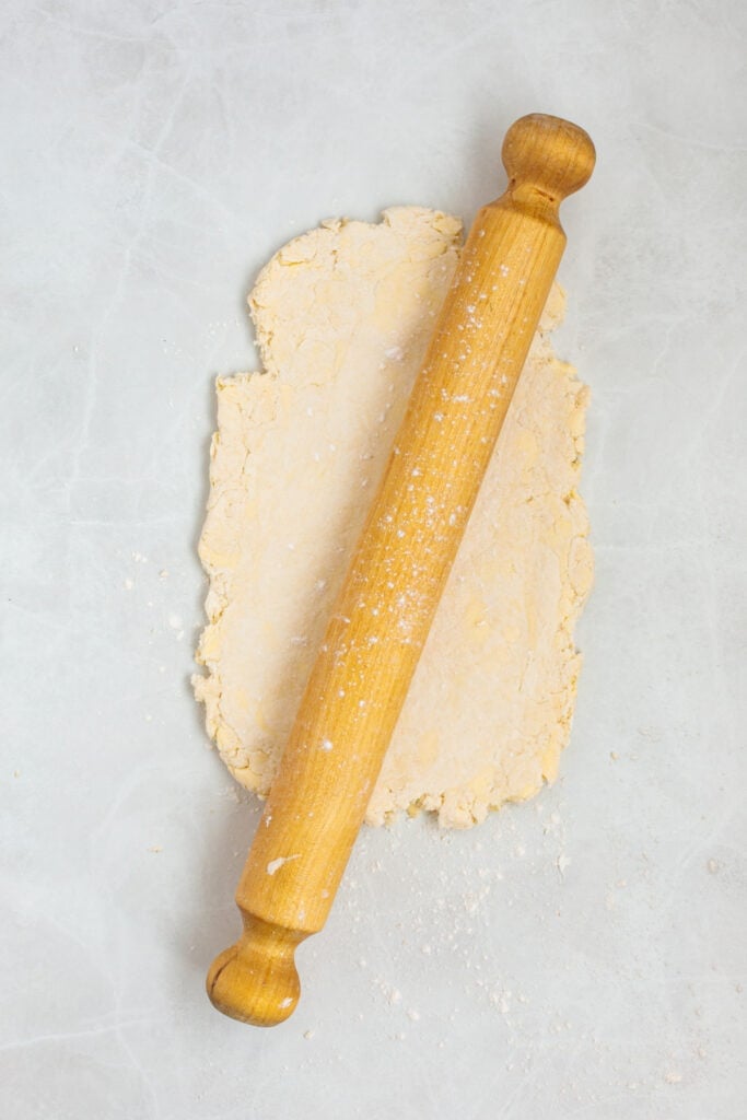 Biscuit dough shaped into a rectangle on a lightly floured surface before folding.