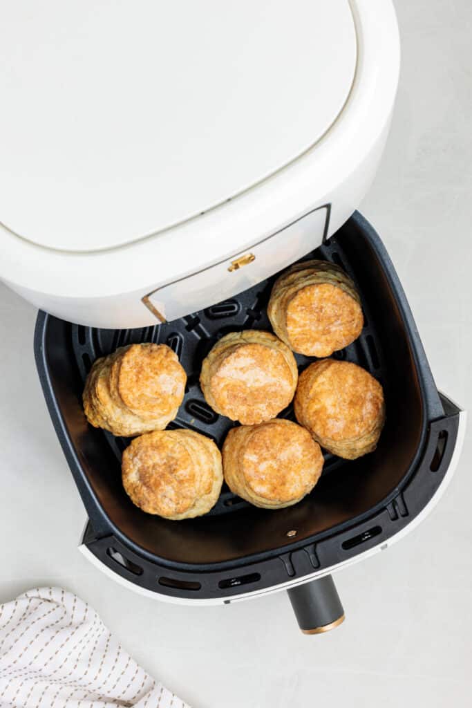 Golden brown sour cream biscuits freshly cooked in an open air fryer basket.