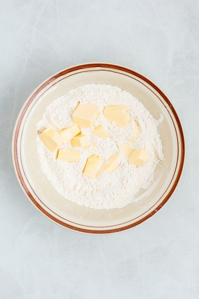 Butter being worked into the flour mixture for homemade sour cream biscuits.