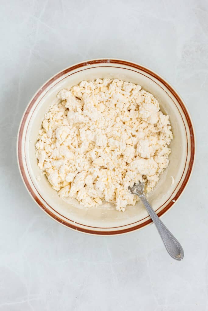 Sour cream biscuit ingredients being mixed together in a large bowl.