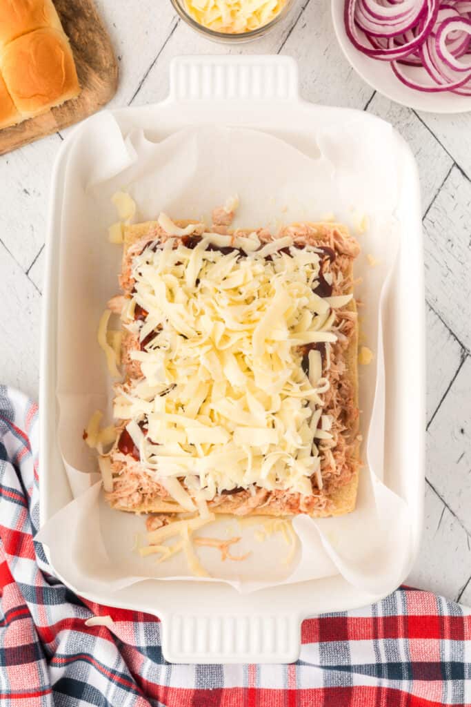 Shredded mozzarella sprinkled over the BBQ chicken slider filling.