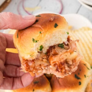 BBQ pulled chicken sliders with saucy shredded chicken, melted cheese, red onion, and golden buttery buns.